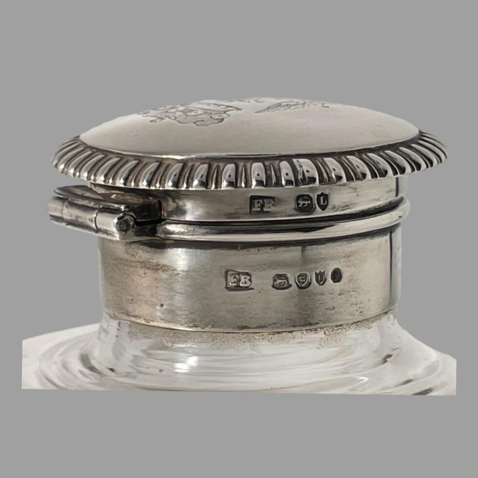Close up photo of the hallmarks on the silver top. The fuller hallmark and makers initials are on the neck while the shorter hallmark plus makers initials are just above it on the top opening part of lid.