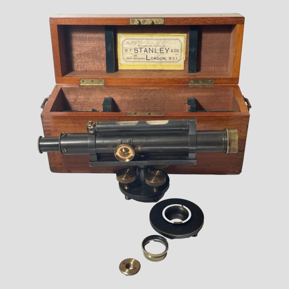 Main photo of Stanley architects spirit level displayed lengthways outside of its open box with the extra small pieces laid in a row in front of the level. The eye end of the level is on the left. An original label for W. F. Stanley & Co can be seen inside the lid with the Holborn address and dated 8/16/35