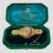 Main photo of c1906 Chester gold brooch displayed inside its original green velvet box with turquoise blue silk lining inside the lid with the Scottish retailers details in gold print. The brooch is a nice solid piece unusual for the period with a regal look about it. At the centre is a disc with diamond in the very middle inside an eight pointed star. Around this star is a frame of 12 seed pearls. The central area of the brooch is the widest with intricate gold detail including rope twists and small golden balls. This is a short and squat brooch with much intricate detail.
