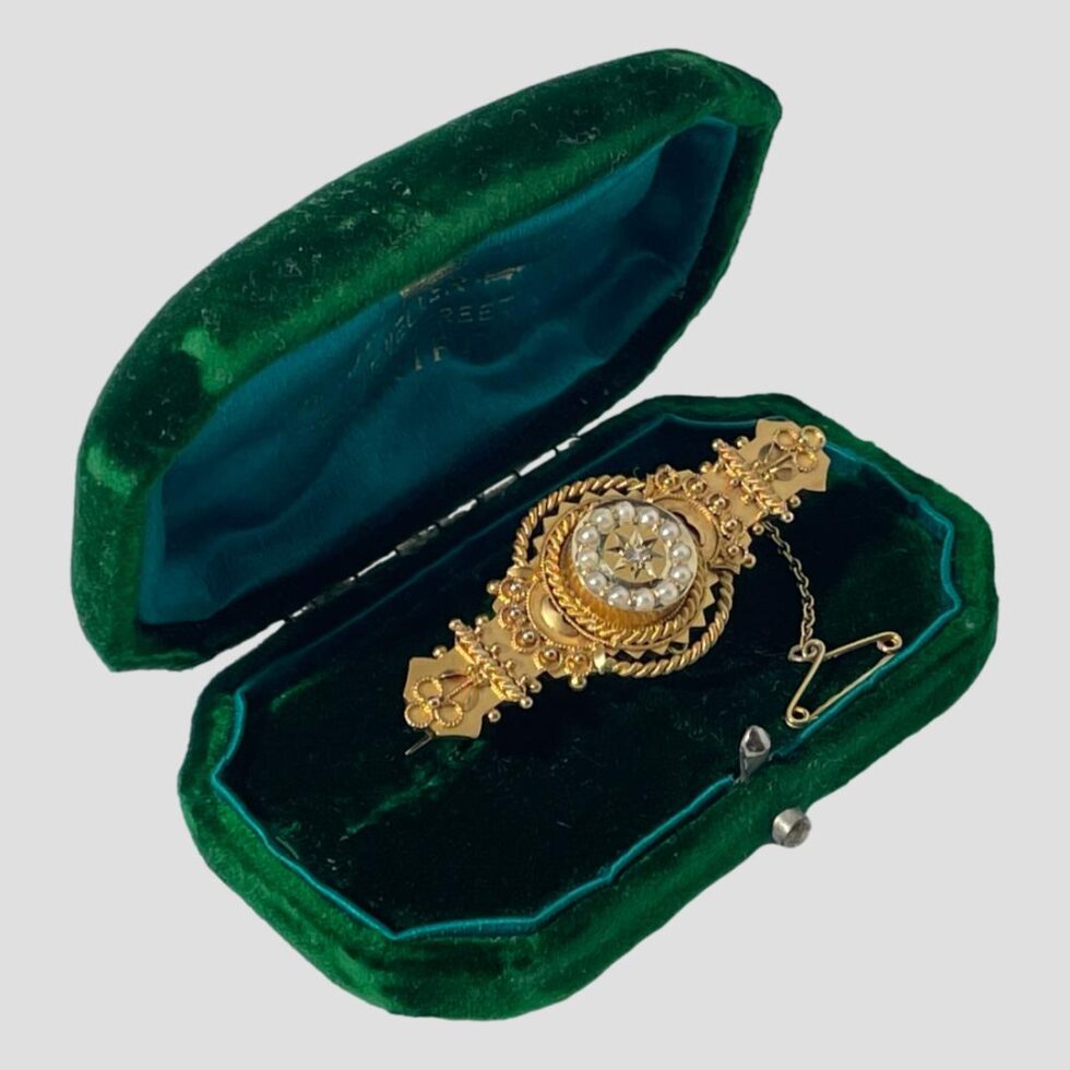 Photo of Edwardian gold brooch still inside of its green velvet box this time with the opened side facing towards the right.