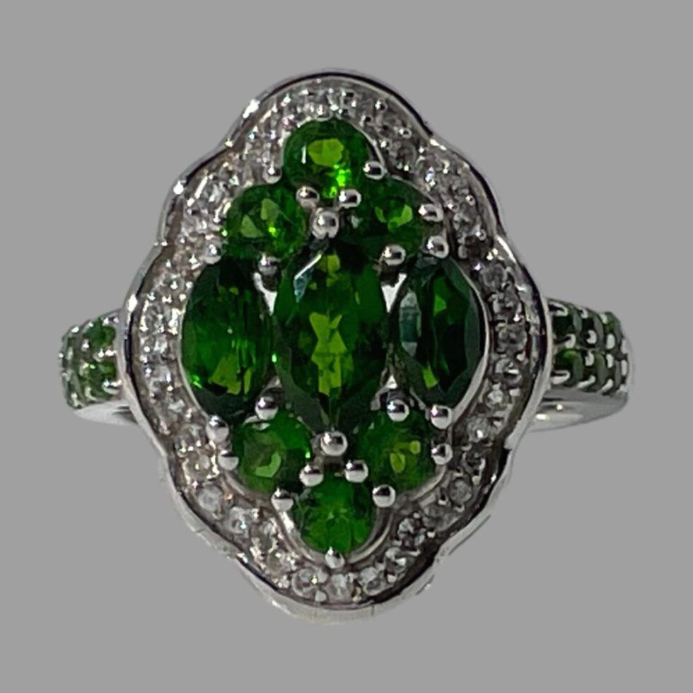 Photo of chrome diopside ring displayed on a flat surface and forward facing. The ring is shown in close up.