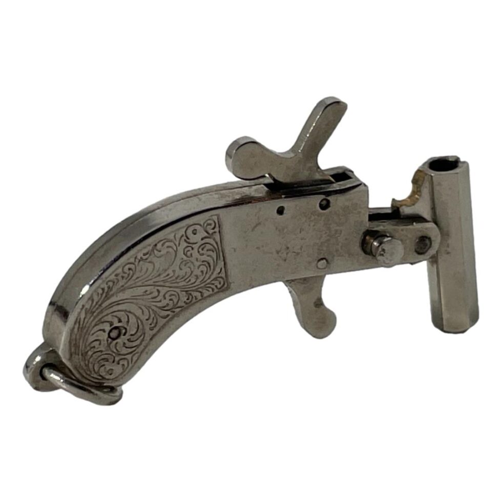 Photo of the Maus cap gun seen with the barrel cocked and trigger pulled back. The handle is on the left.