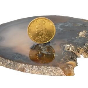 Main photo of 22Kt gold sovereign c1895 displayed on top of a slice of natural agate with the 'old head' portrait of Queen Victoria on display. The coin is displayed upright on the agate.