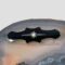 Main photo of black enamel mourning brooch displayed on a slice of natural agate with the brooch front forward facing. The brooch is oblong in shape with rounded petal like ends. The centre of the brooch which holds the seed pearl is widest with blunt points as if a cross had been marked at the centre and jutted out. The seed pearl sits inside a 6 pointed star with 2 long arms to the left and right of pearl. Within these arms are 4 silver spots, the same spots hold the pearl in place at the centre. Although originally worn for mourning, this brooch would not look amiss as a regular accessory and could even work as a tie pin.