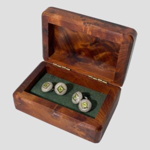 Main photo of Links silver peridot cufflinks displayed inside their wooden box with all the main sides of the cufflinks on display (all sides with peridot) The box appears to be a walnut burr and is a rich orangey brown and there is some green felt like material inside the box with black elastic where the cufflinks are threaded though.