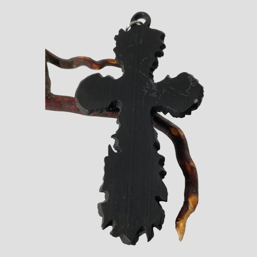 Photo of the back of the carved bog oak cross still shown leaning against the twig of cherry.