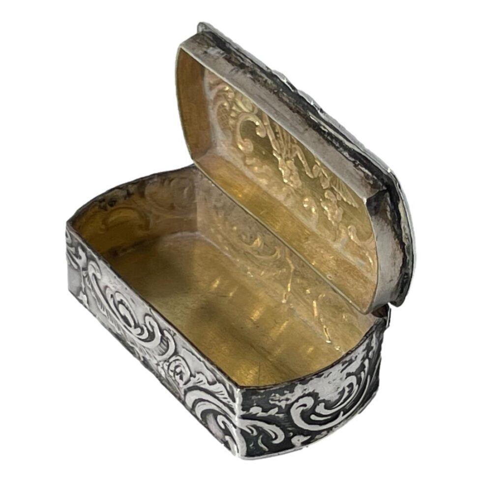 Photo showing the small Continental silver box open revealing the gilt interior. The opening side of the box is facing to the bottom left corner.