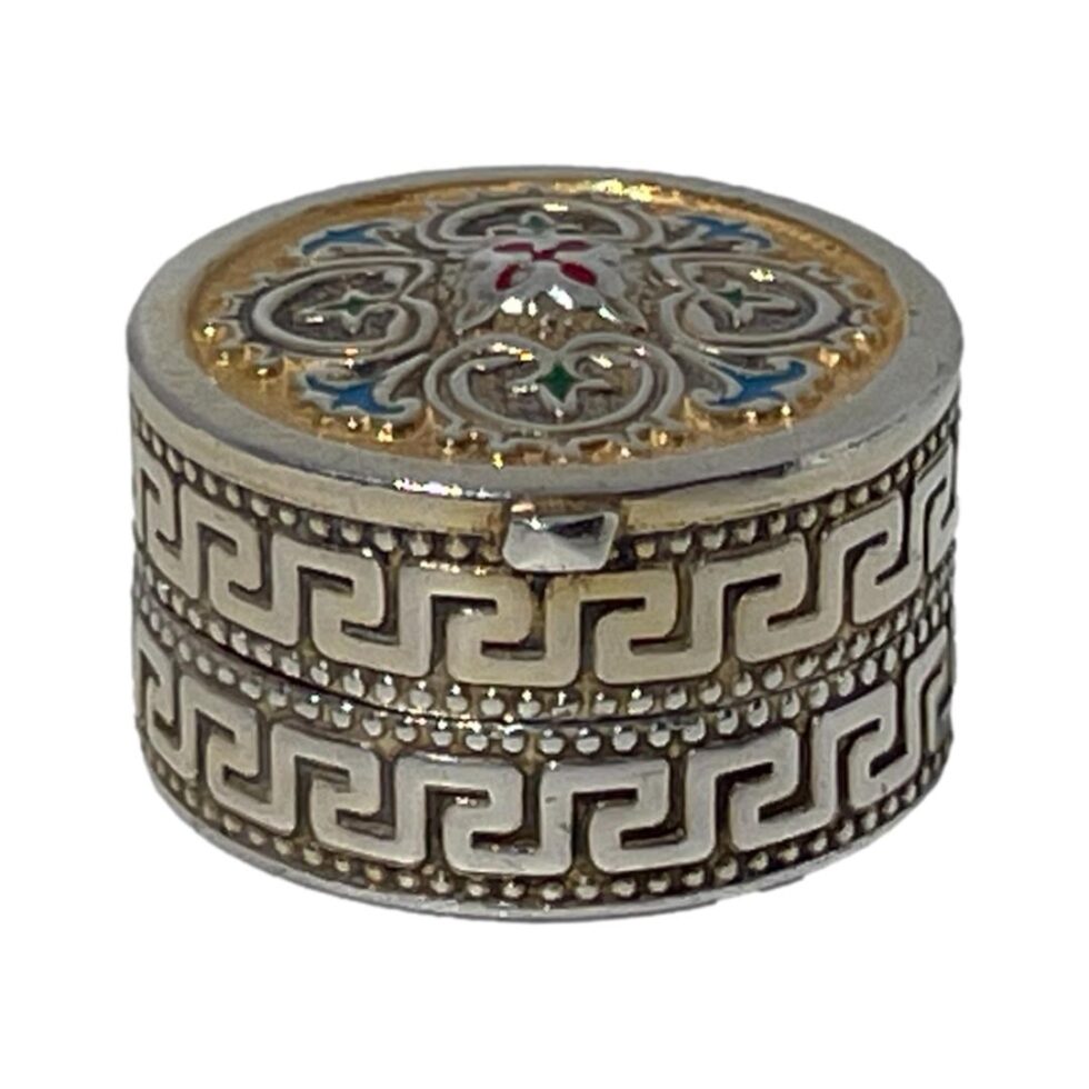 Photo of box seen from a more eye level angle with the meander pattern clearly on display along the top and bottom around the whole side. The golden yellow, red, green and blue enamelling on the lid gives an Eastern look to the box.