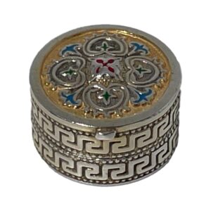 Main photo of silver enamel pill box seen from a raised angle looking diagonally down with the enamelled lid in full view and most of the meander pattern around the side.