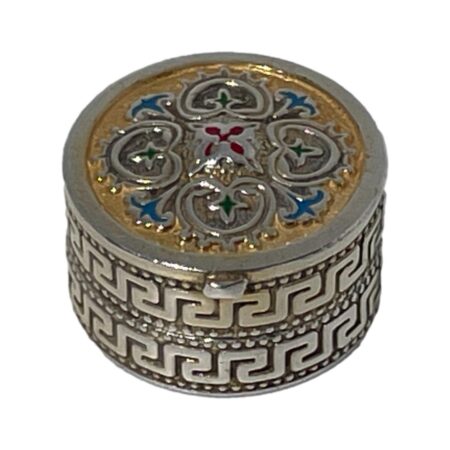 Main photo of silver enamel pill box seen from a raised angle looking diagonally down with the enamelled lid in full view and most of the meander pattern around the side.