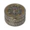 Main photo of silver enamel pill box seen from a raised angle looking diagonally down with the enamelled lid in full view and most of the meander pattern around the side.