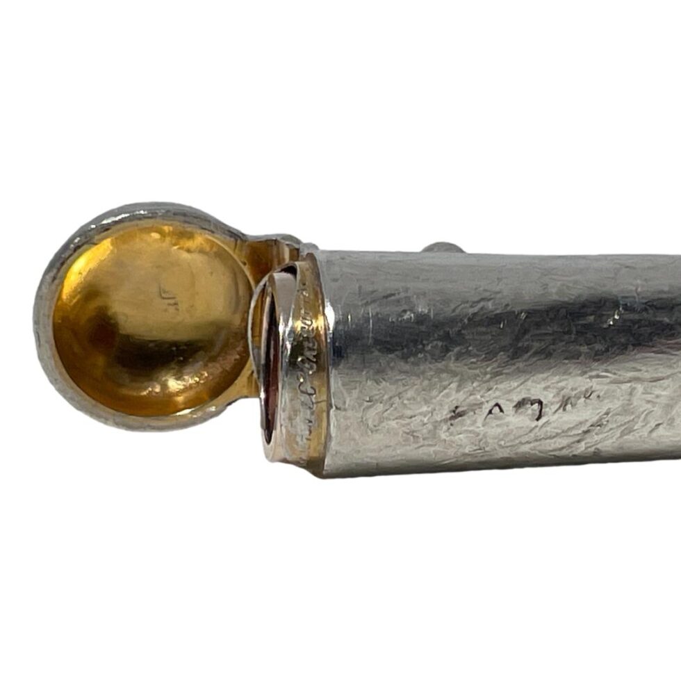 Photo of the wider end of the cheroot case shown open. The hallmark is just visible to side of the case body and only slightly visible inside the lid. The impressed 'Hamilton & Co, Calcutta' is visible around the inside lip of the case. The gilt on the lip is slightly worn.