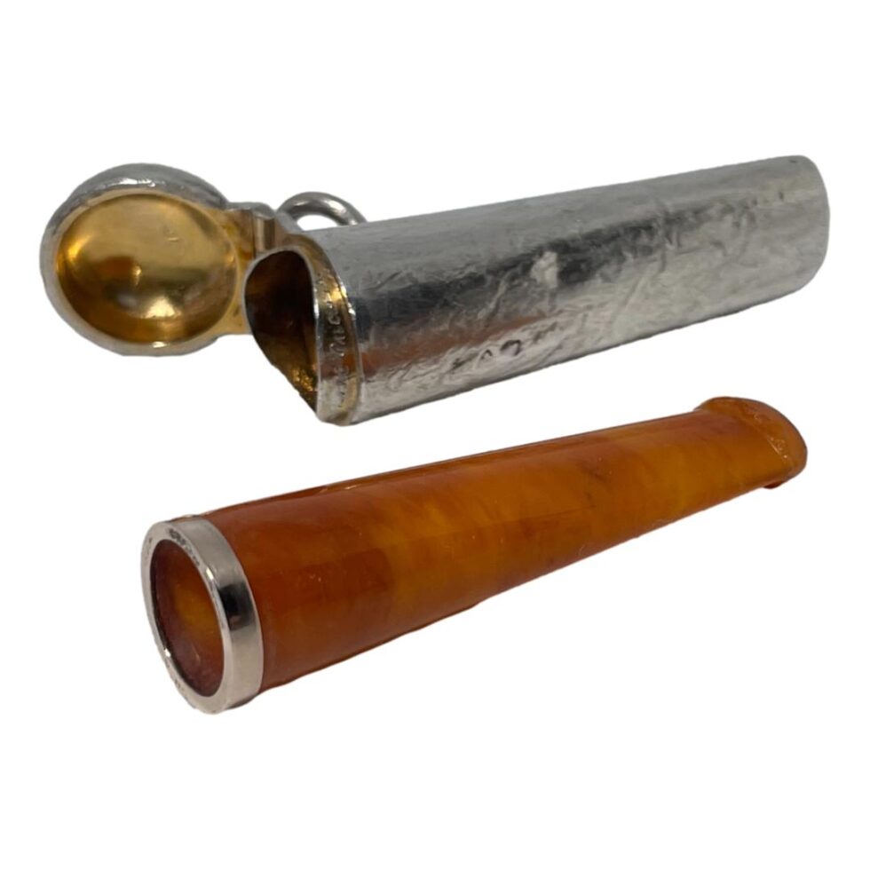 Photo of the cheroot now removed from its case and laid in front of it. Both pieces are laid diagonally with the wider ends facing slightly to bottom left. The cheroot is in lovely almost unused condition.