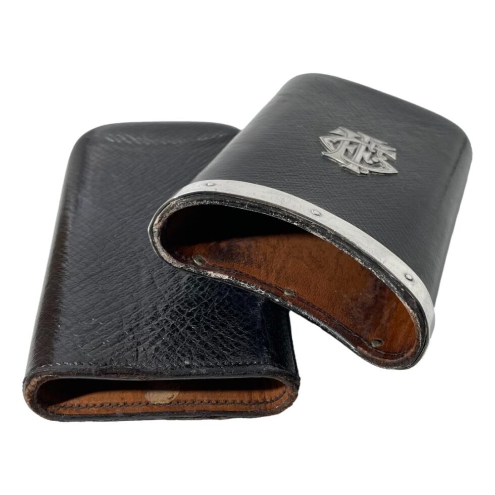 Photo of leather cigar case with the outer pocket removed and laid leaning against the inner pocket. The open ends of both pockets are in the foreground. The wear of the leather on both pockets is visible.