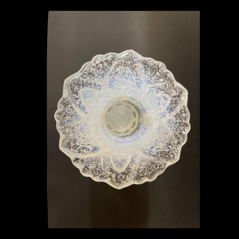 Photo looking straight into the sconce of one of the Vaseline glass candlesticks. Could be a snowflake!