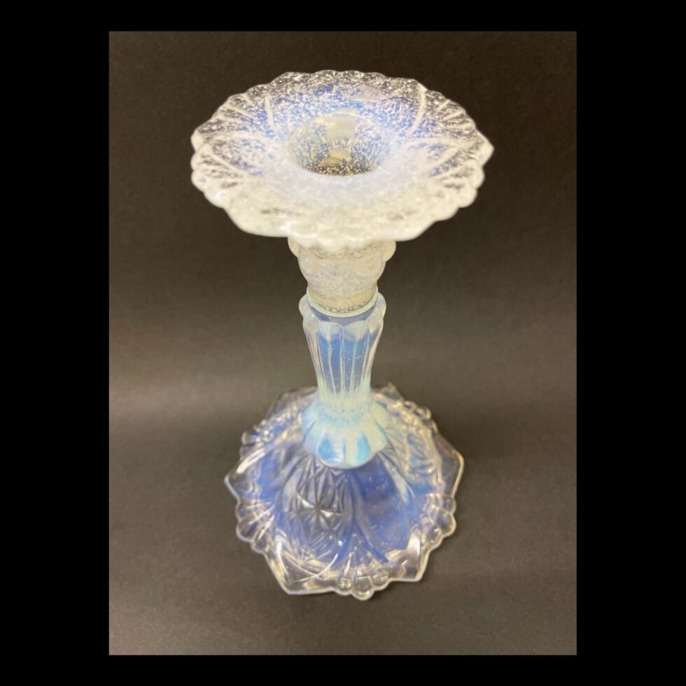 Photo of a single vaseline glass candlestick looking down from a slightly raised angle diagonally.
