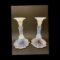 Main photo of 1930s Vaseline glass candlesticks displayed side by side at an eye level. The sconce area appears white but has flecks of white and blue and below the sconce the candlesticks are an almost luminescent Vaseline blue. The background is a dark grey to show up the colours of the candlesticks better.